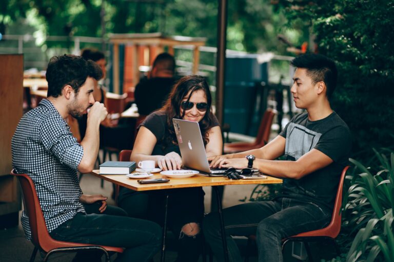 3 people in a cafeteria are engaging with their blog comunity.